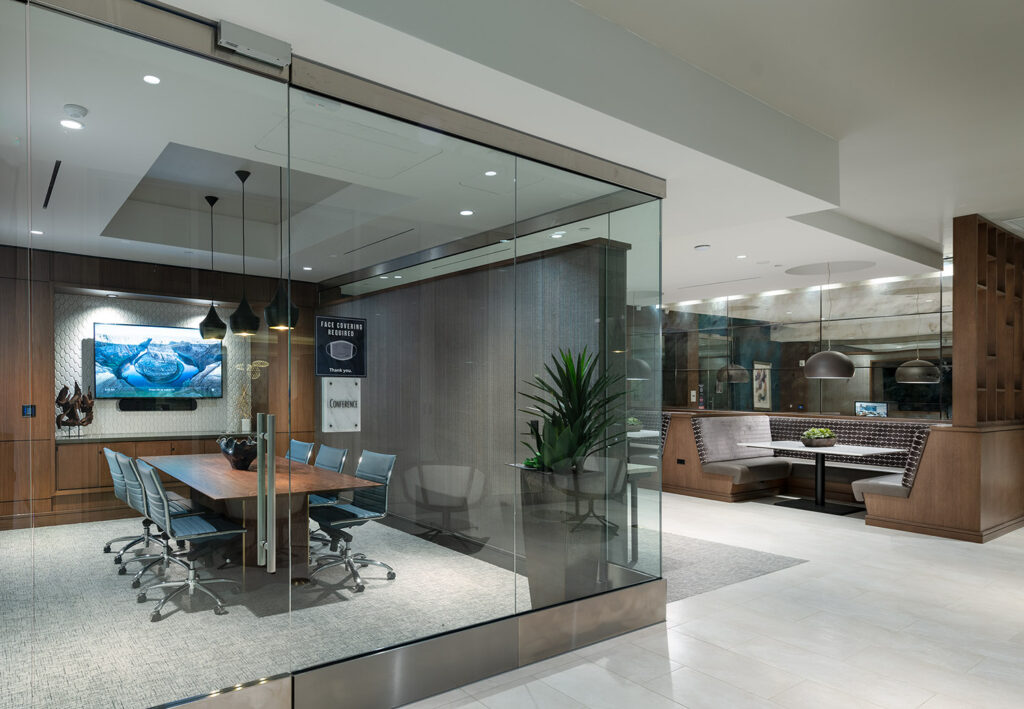 Glass enclosed conference room with conference table and chairs and a flat screen TV