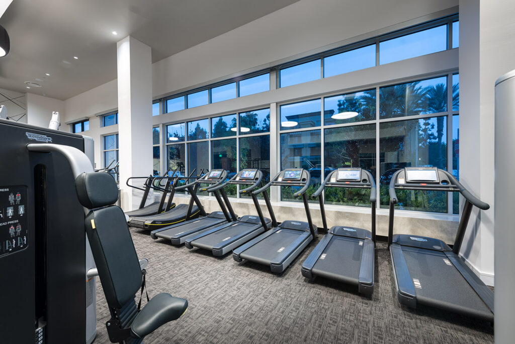 Fitness center with row of treadmills and large windows