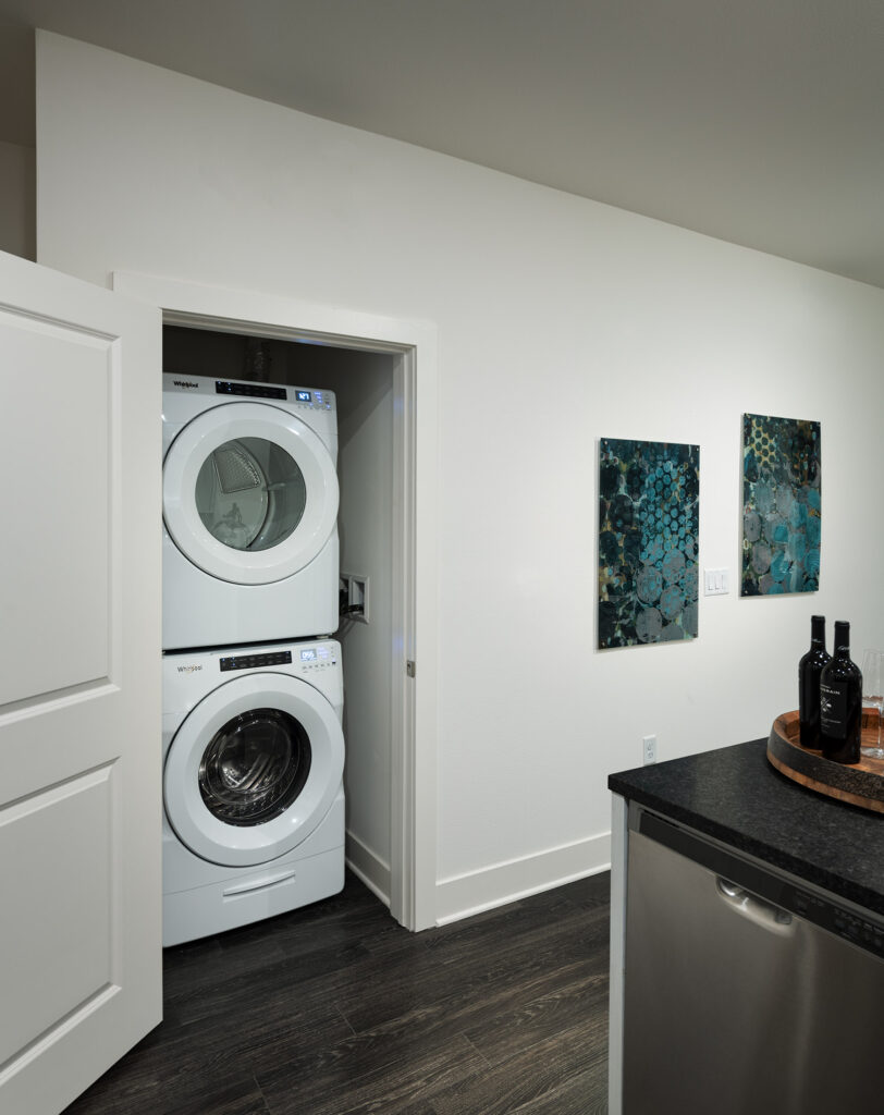 Laundry closets off the kitchen with stacked washer and dryer